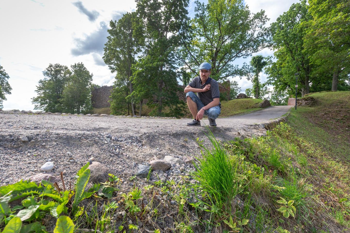 Viljandi pärimusmuusika keskuse haldusjuht Peedu Põld näitab kohta, kust teetammi kindlustavad kivid on minema uhutud.
