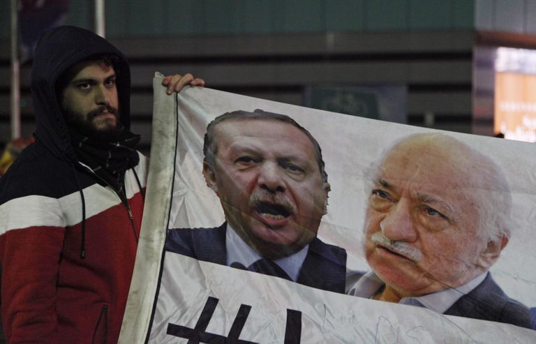 AKP vastu meelt avaldav mees 2013. aasta detsembris plakatiga, kus Recep Tayyip Erdoğan ja Fethullah Gülen on seatud kõrvuti.