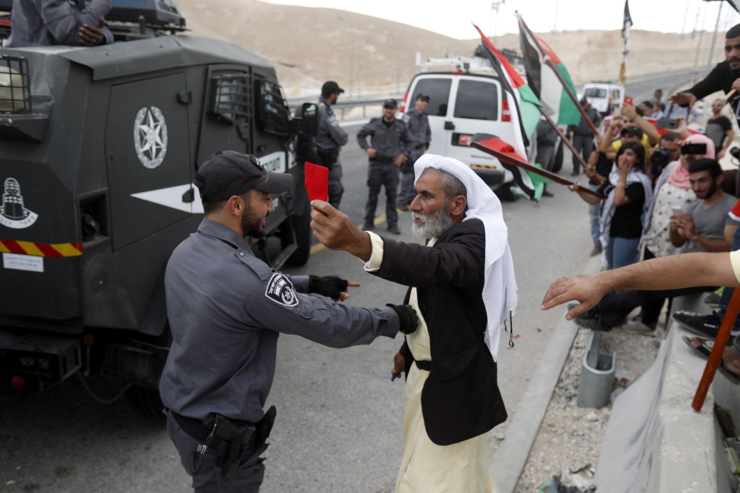 Demonstrators scuffle with Israeli troops as others wave Palestinian flags during a protest against Israel's plan to demolish the Palestinian Bedouin village of Khan al-Ahmar, located between the West Bank city of Jericho and Jerusalem near the Israeli settlement of Maale Adumim