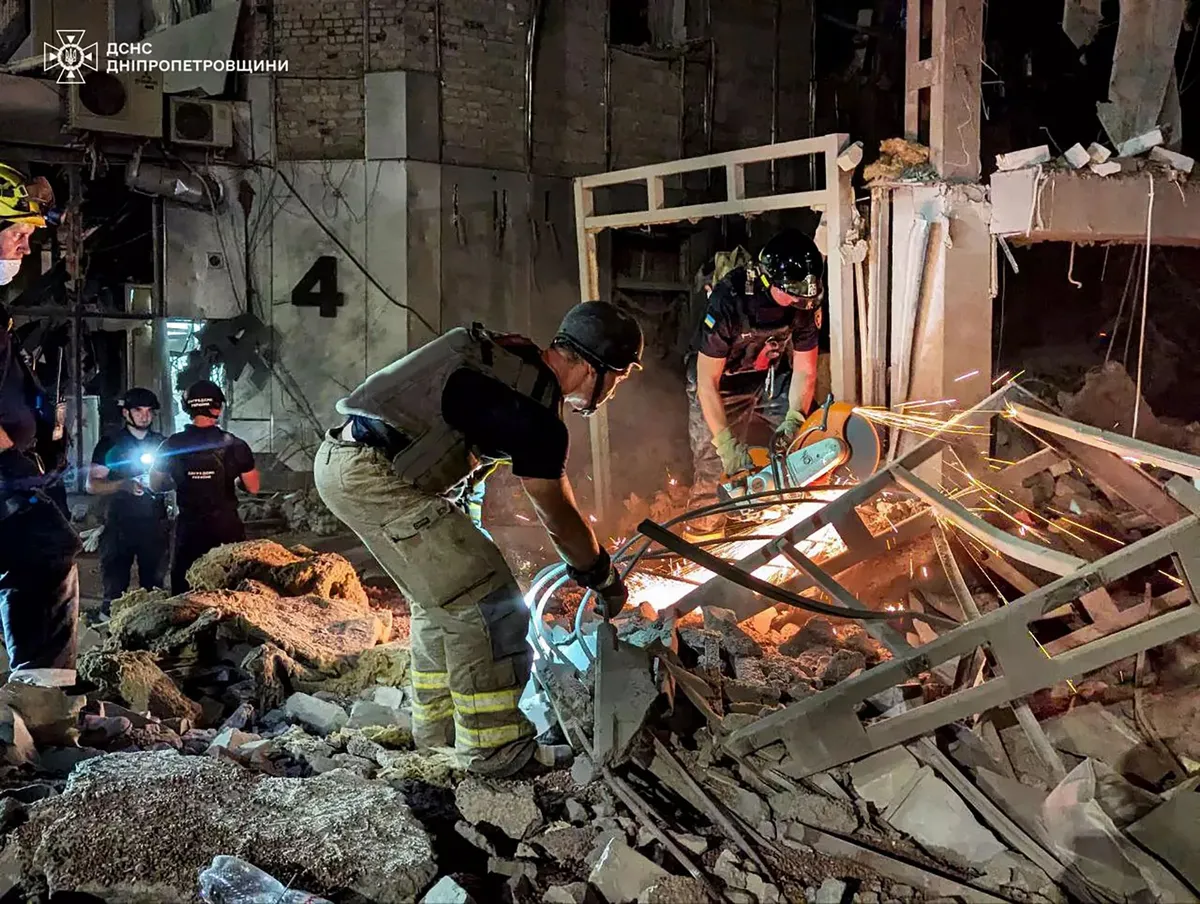 This handout photograph taken and released by the Ukrainian Emergency Service on August 27, 2024 shows rescuers in action on a site of a heavily damaged hotel following an air attack in Kryvyi Rig.