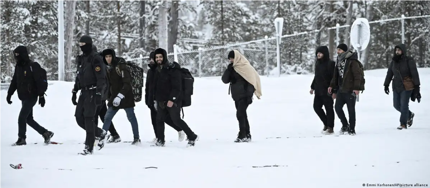 Финские пограничники сопровождают мигрантов, которые прибыли на границу со стороны России