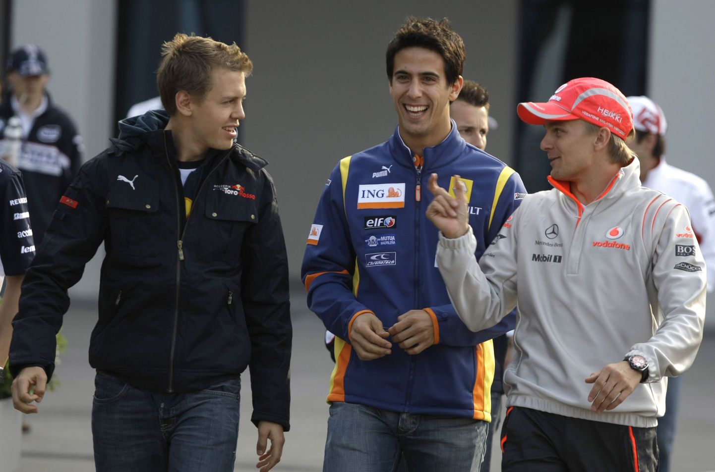 Renault testisõitja Lucas di Grassi (keskel sinises) koos kolleegidega. Vasakul Sebastian Vettel Toro Rosso ridadest ning paremal Heikki Kovalainen McLarenist.