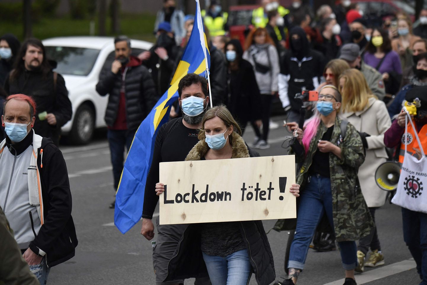 Protestētāja ar plakātu "Lokdauns nogalina" Berlīnē