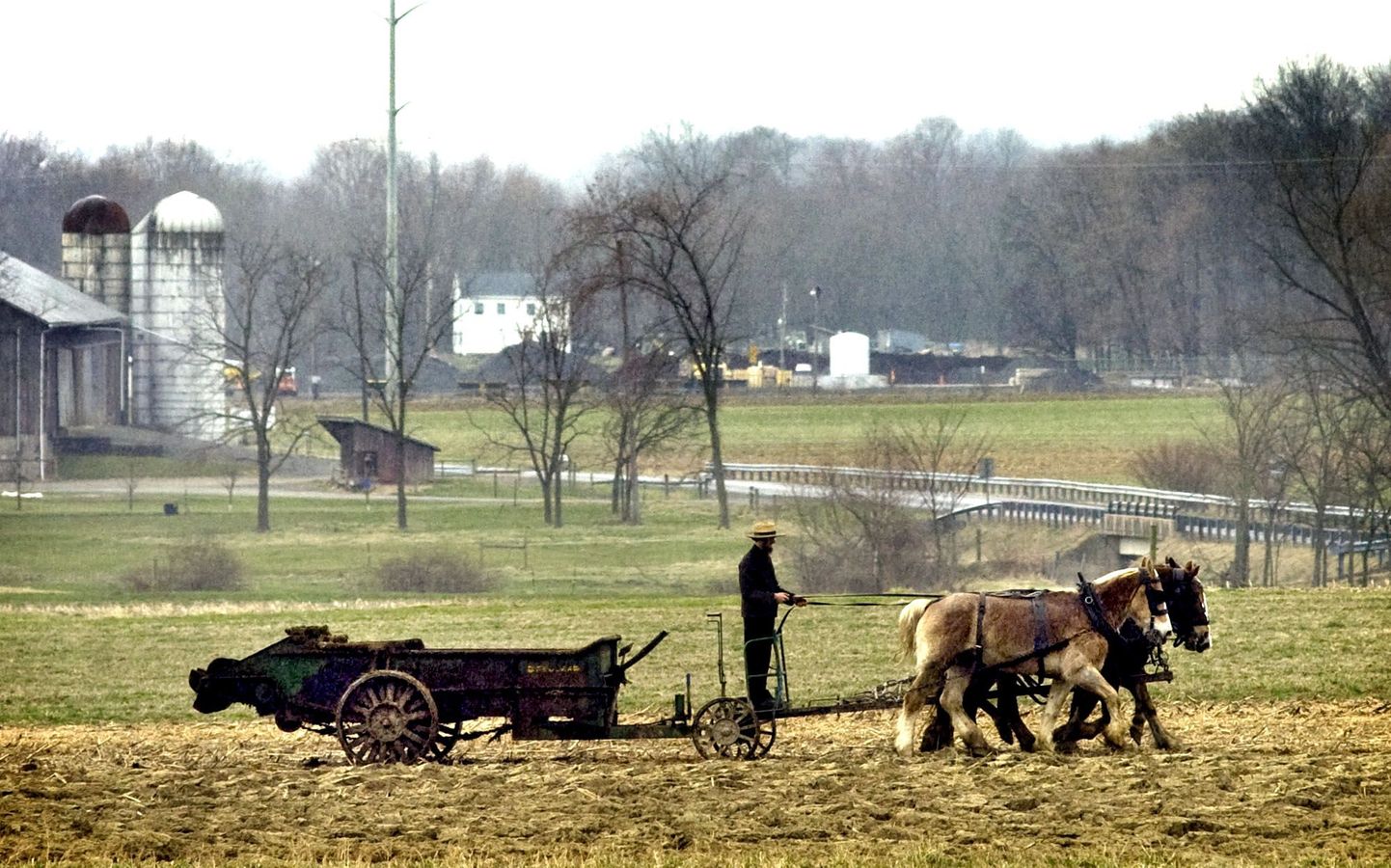 An Amish farmer drives a team of horses pulling a manure spreader across a field for an early-spring application of fertilizer in Anthony Township, near Washingtonville, Pa., on Monday morning, March 22, 2010. (AP Photo/Bloomsburg Press-Enterprise, Bill Hughes) / SCANPIX Code: 436