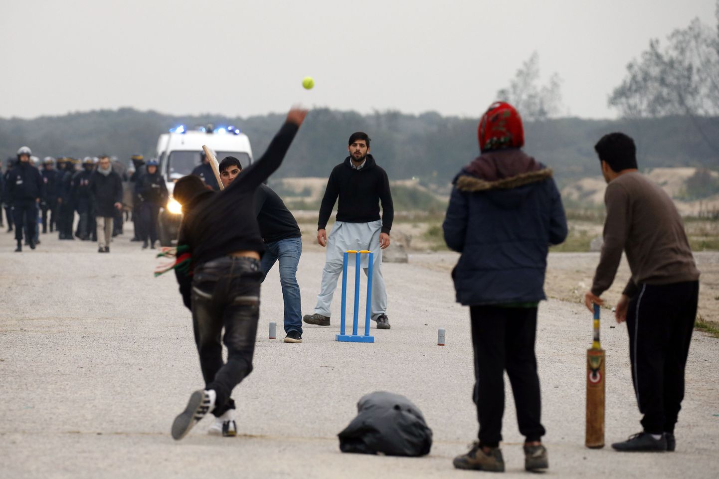Беженцы играют в крикет в Кале.