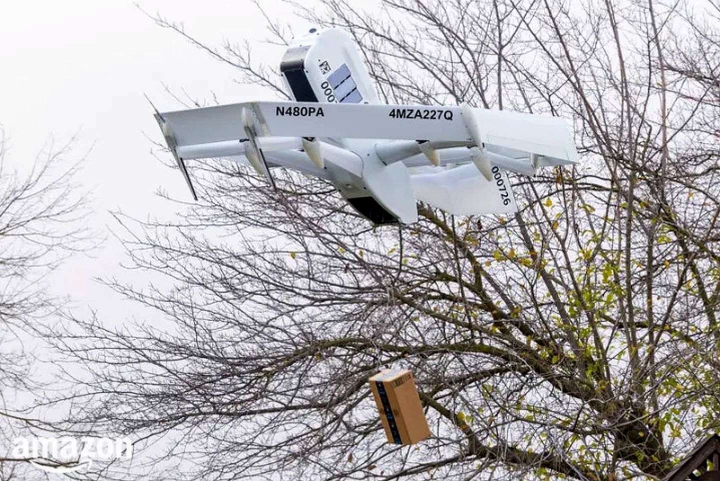 Amazoni uus droon Prime Air lendab tellija kohale ja laseb pika trossi otsas paki alla maa peale.
