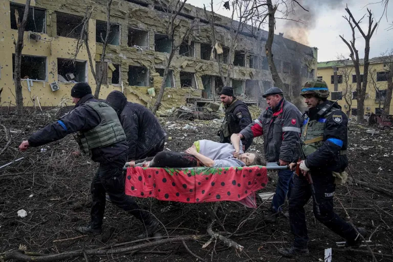 Девушка на носилках, после удара по роддому в Мариуполе.
