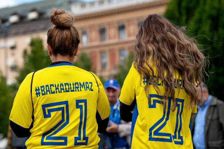 Rootslannad, seljas oma maa jalgpalli rahvuskoondise särk, millele on kirjutatud #BACKADURMAZ ja Jimmy Durmaze mängijanumber.