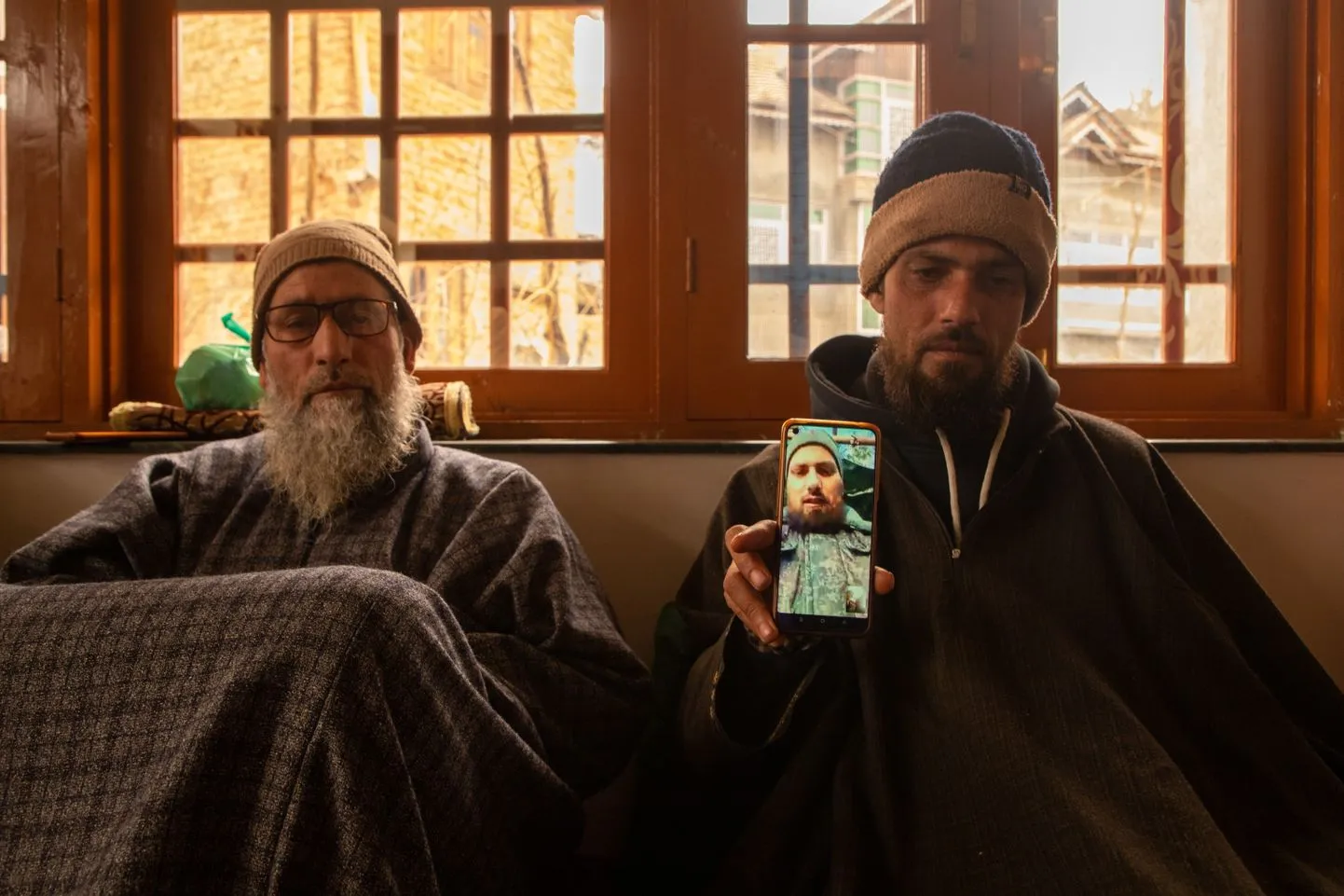 Индиец показывает на смартфоне фотографию своего брата, которого заманили на работу в Дубай и отправили в Россию, где он вынужден воевать против Украины.