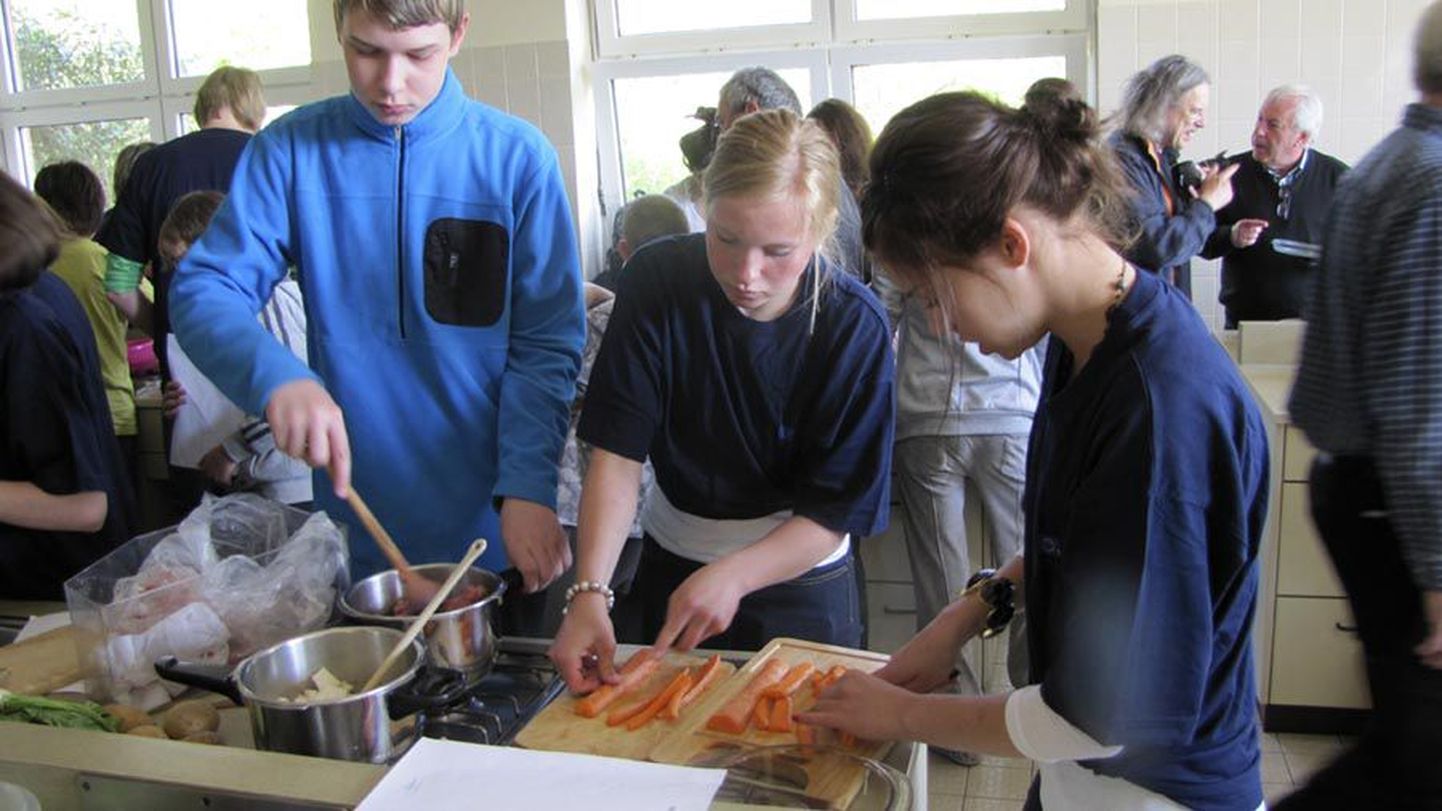 Viljandi maagümnaasiumi õpilane Risto Luur ja saksa tüdrukud üheskoos kokkamas