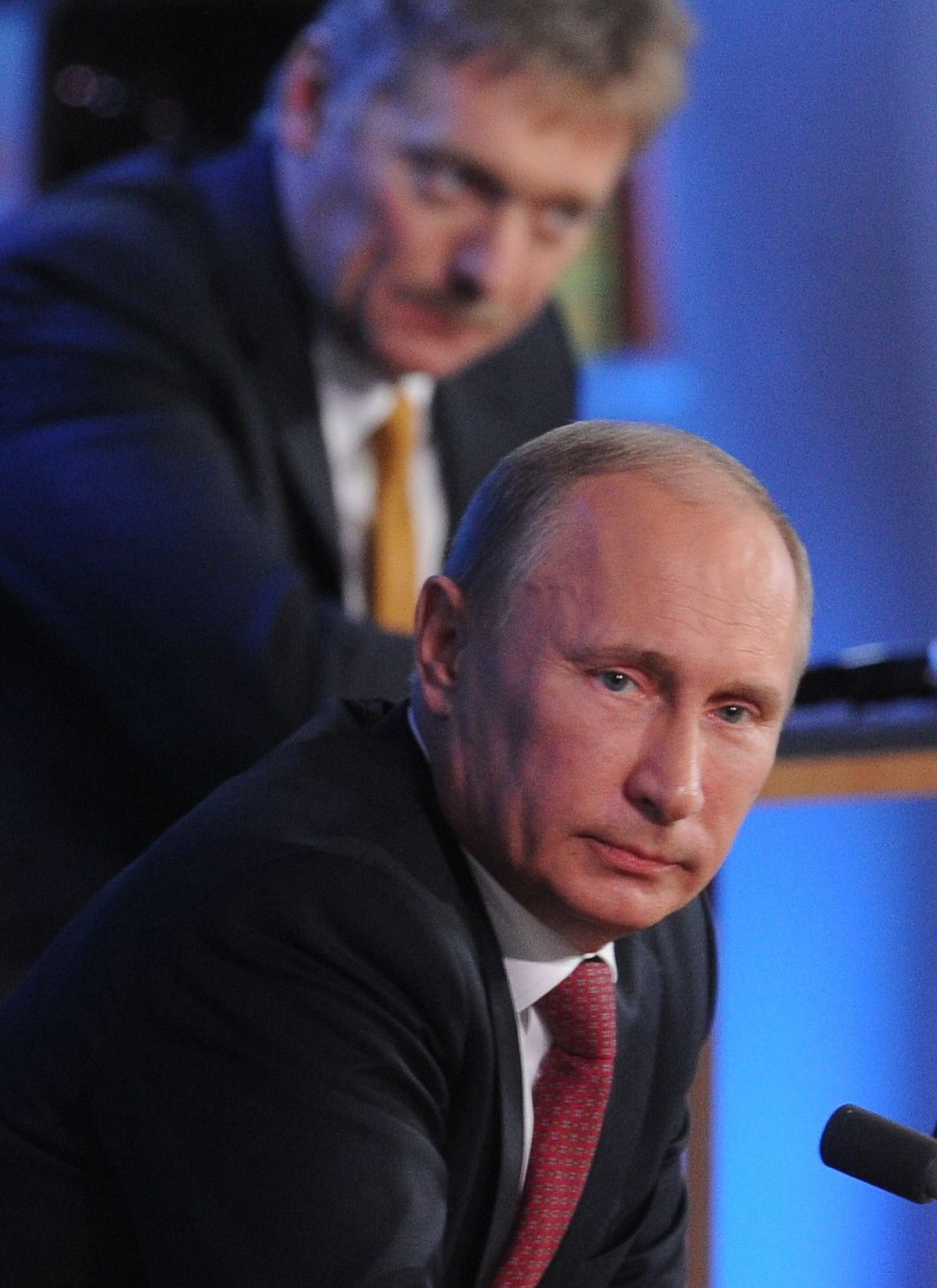 Vene president Vladomir Putin. Tema selga taga paistab pressisekretär Dmitri Peskov.
