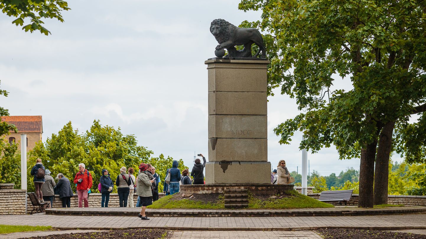 Туристы в Нарве у скульптуры "Шведский лев".