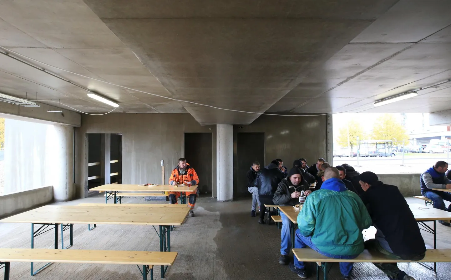 Eesti ehitusmees (vasakul) ja võõrtöölised võtavad pruukosti TÜ kliinikumi sarikapeol.