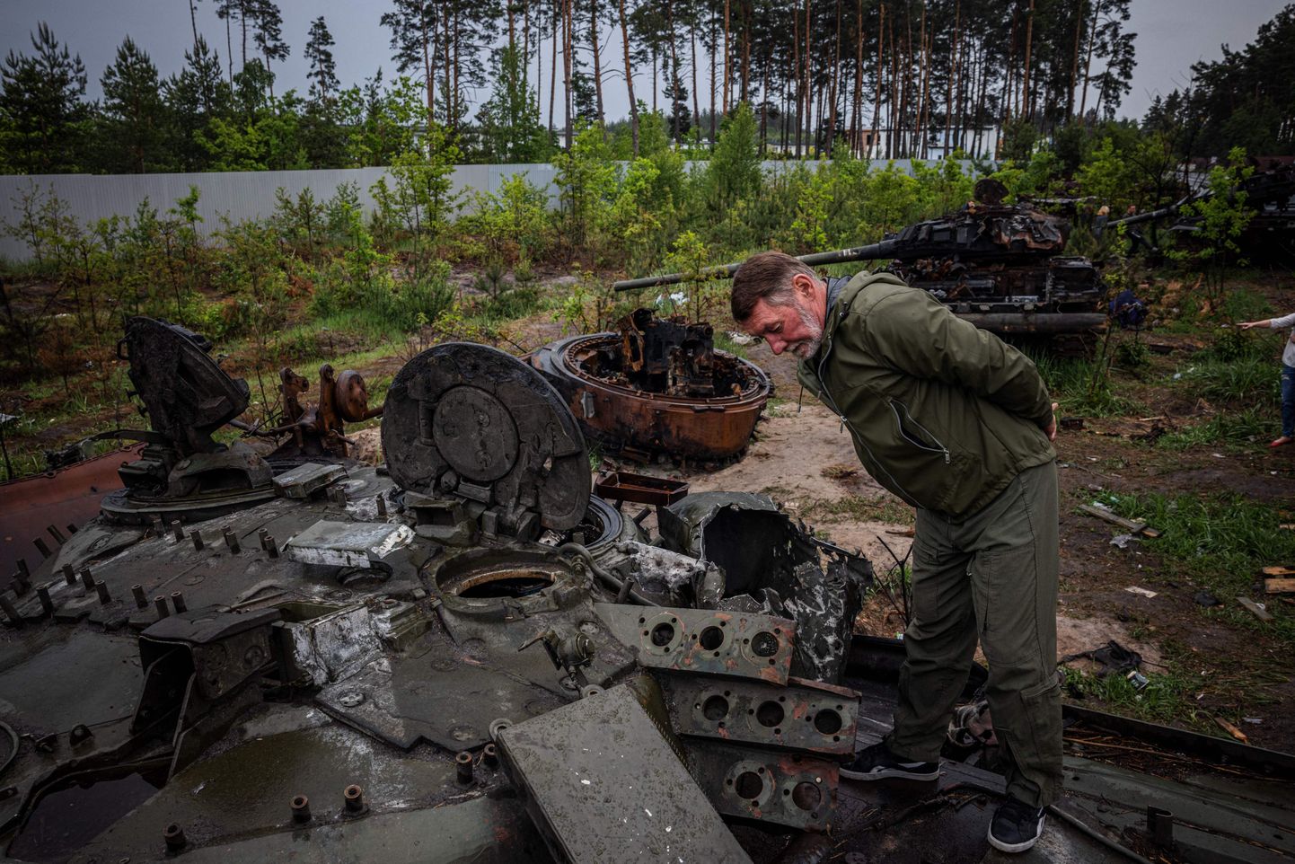 Местный житель осматривает подбитый российский танк под Киевом 31 мая 2022 года