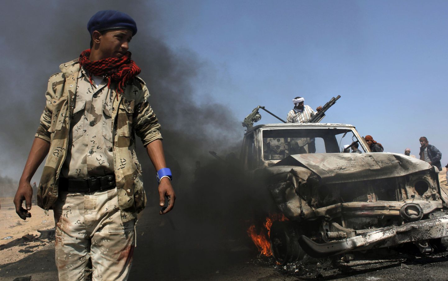 Liibüa mässuline rusudes sõjaväeauto juures.