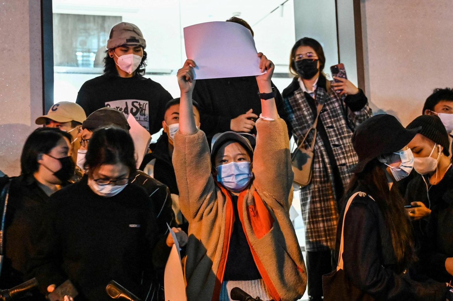 Protesti märgiks tühja paberilehte käes hoidev naine eile Shanghais meeleavaldusel Hiina koroonapoliitika vastu.